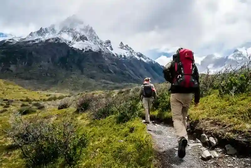 Hikers ascending the Franconia Ridge Loop with snow-capped peaks in the background